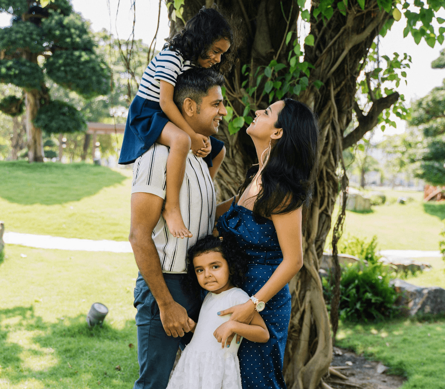 Family standing together under tree in park
